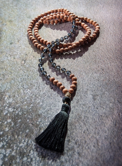 Kette im Mala Look mit natürlichem Bayongholz, hochwertigen Kristallen und schwarzer Quaste.