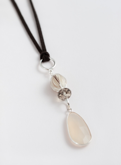 Preview: Boho Anhänger aus Sterling Silber mit großem Mondstein, Kristallperle und gebürsteter Olive, an Kunstlederband getragen.