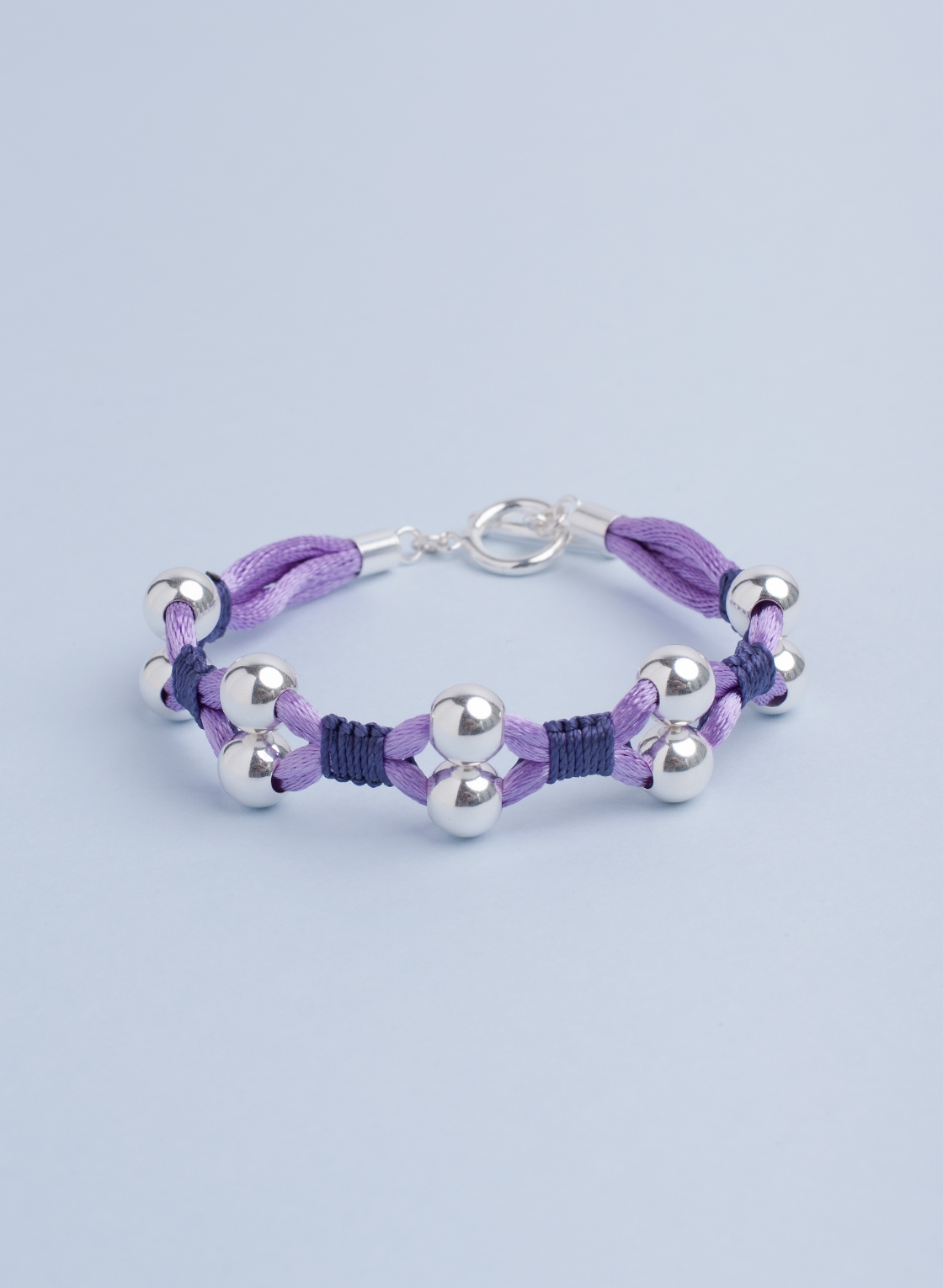 Statement Armband mit Sterling Silber Kugeln in 8 mm, pastell Lila Satinband und feinem Makramee in dunkel Lila.
