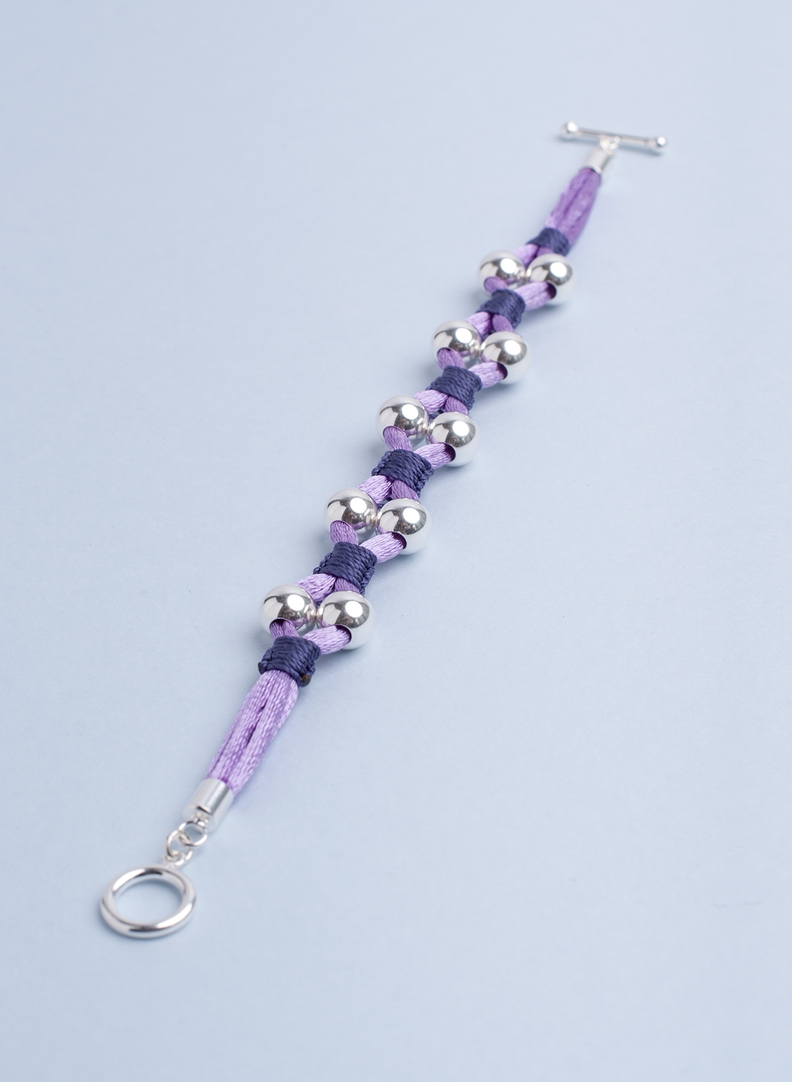 Statement Armband mit Sterling Silber Kugeln in 8 mm, pastell Lila Satinband und feinem Makramee in dunkel Lila.