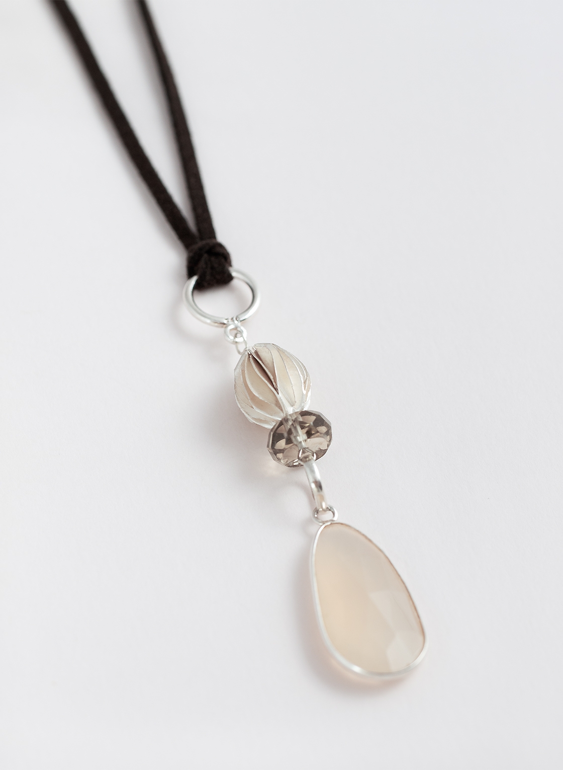 Boho Anhänger aus Sterling Silber mit großem Mondstein, Kristallperle und gebürsteter Olive, an Kunstlederband getragen.